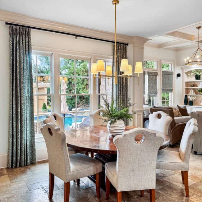 Bright dining area with large windows, cozy curtains, and contemporary lighting, ideal for family meals.