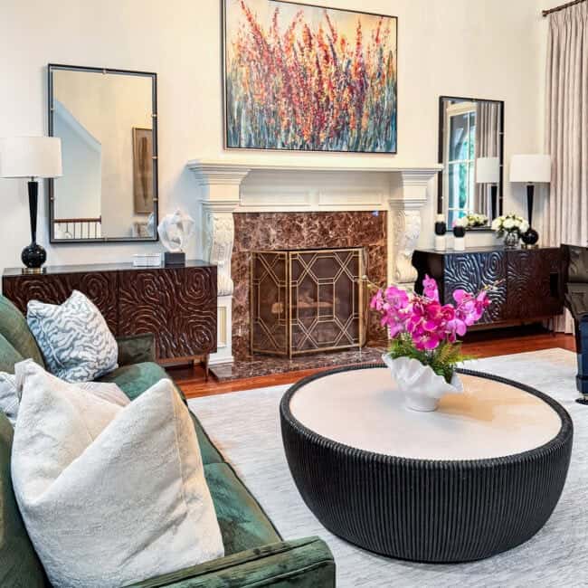 Bright living room with white walls, colorful floral painting, and stylish furniture.