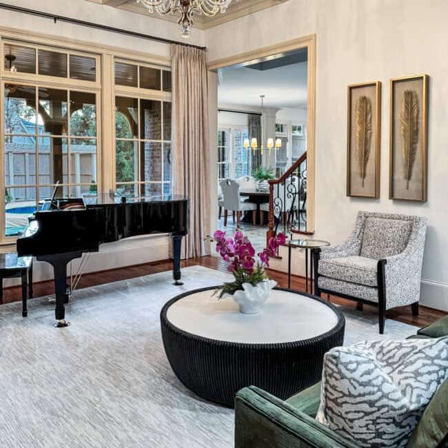 Bright living space with large windows, chandelier, and cozy seating area.