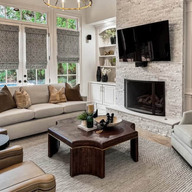 Bright living room with fireplace, large windows, comfortable sofa, and stylish decor.