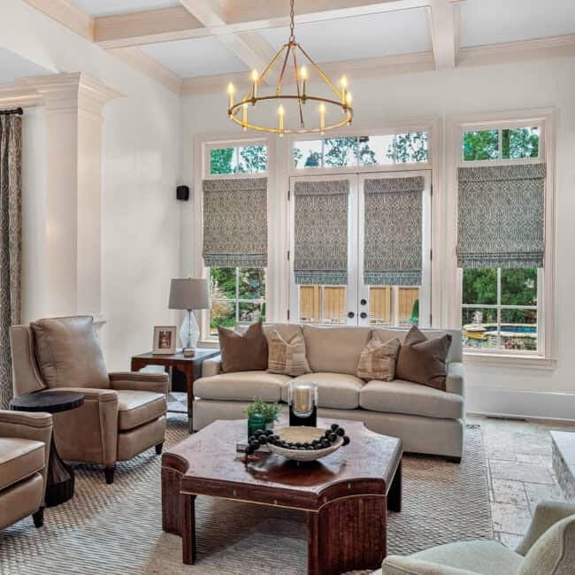 Bright living room showcasing windows, neutral furniture, and decorative accents.
