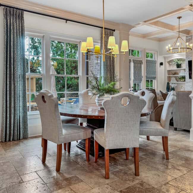 Bright and spacious dining area with large windows, chandelier, and neutral decor. Perfect for family meals and entertaining guests.