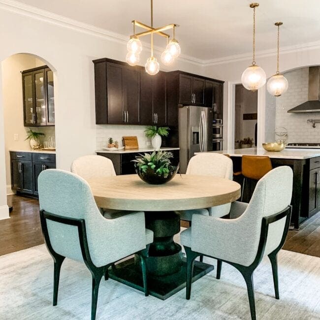 Elegant kitchen with black cabinets and contemporary lighting fixtures.