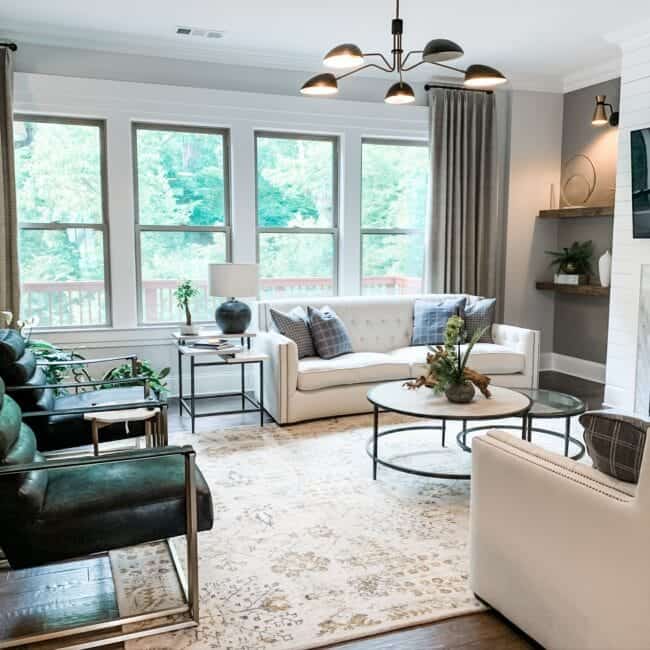 Contemporary living room featuring plush sofas, armchairs, natural light, and modern design.