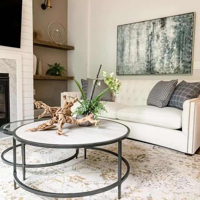 Living room with elegant sofa, abstract art, and decorative elements.