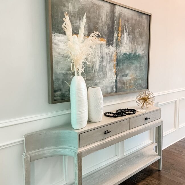 Elegant living room decor with contemporary console and abstract painting.