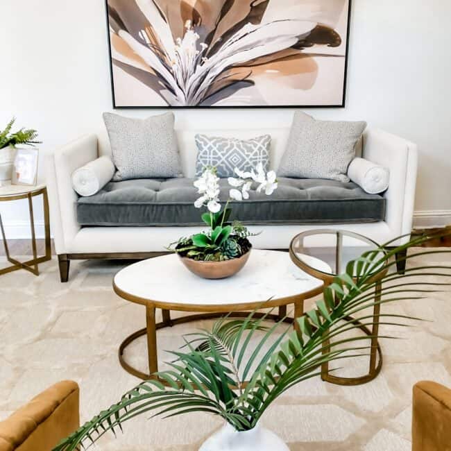 Decorative living room with floral wall art, plush cushions, and stylish furniture.