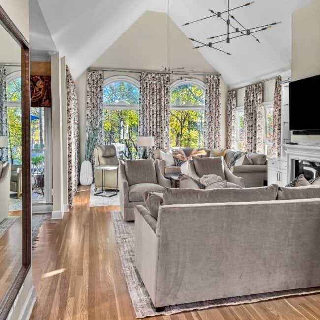 Bright and spacious living room with large arched windows, plush sofas, and stylish decor.