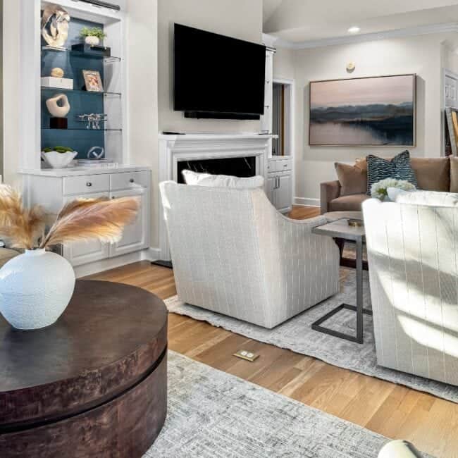 Modern living room with sleek furniture, wall-mounted TV, and decorative accents.