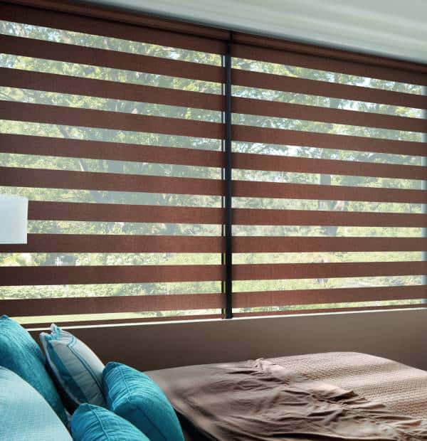 Stylish horizontal wooden blinds covering large bedroom window.