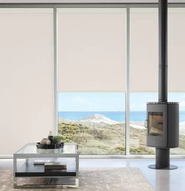 Bright living room with large windows showcasing ocean and dune scenery.