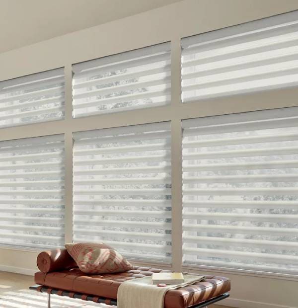Bright white horizontal window blinds in a minimalist room setting.
