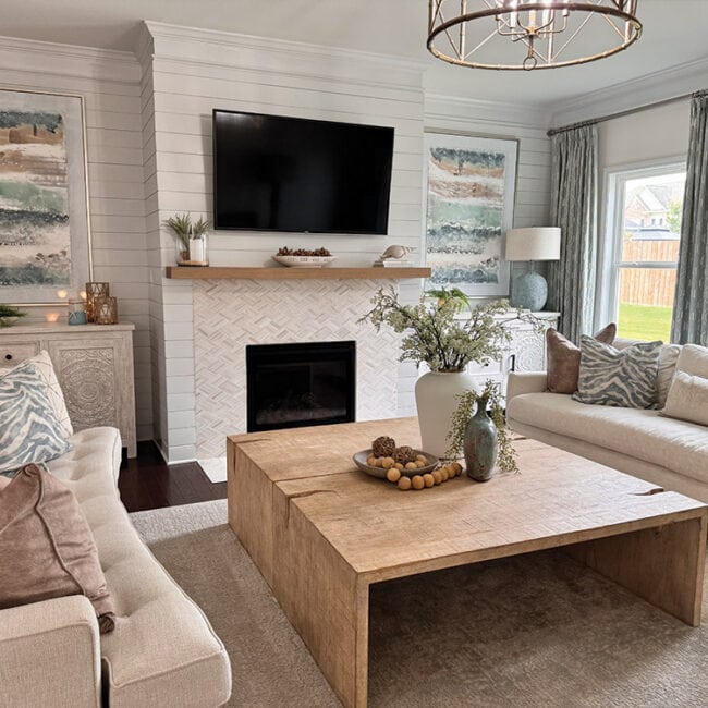 Bright living room with fireplace, TV, and comfortable sofas.