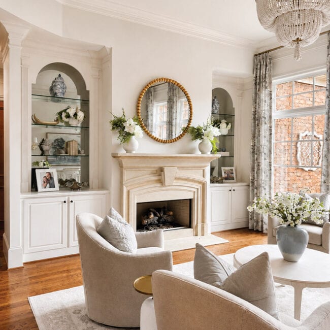 Bright living room with fireplace, chandelier, and cozy seating area.