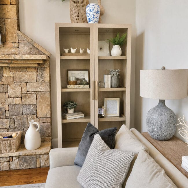 Living room with fireplace, beige cabinet, and decorative vases and plants.