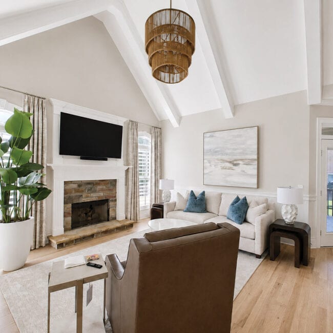 Spacious living room with white walls, large window, and cozy furniture.