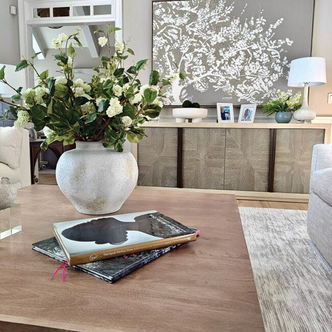 Elegant living room with a large flower arrangement on a wooden table.