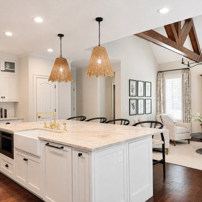 Bright modern kitchen with island, pendant lights, and open living space.